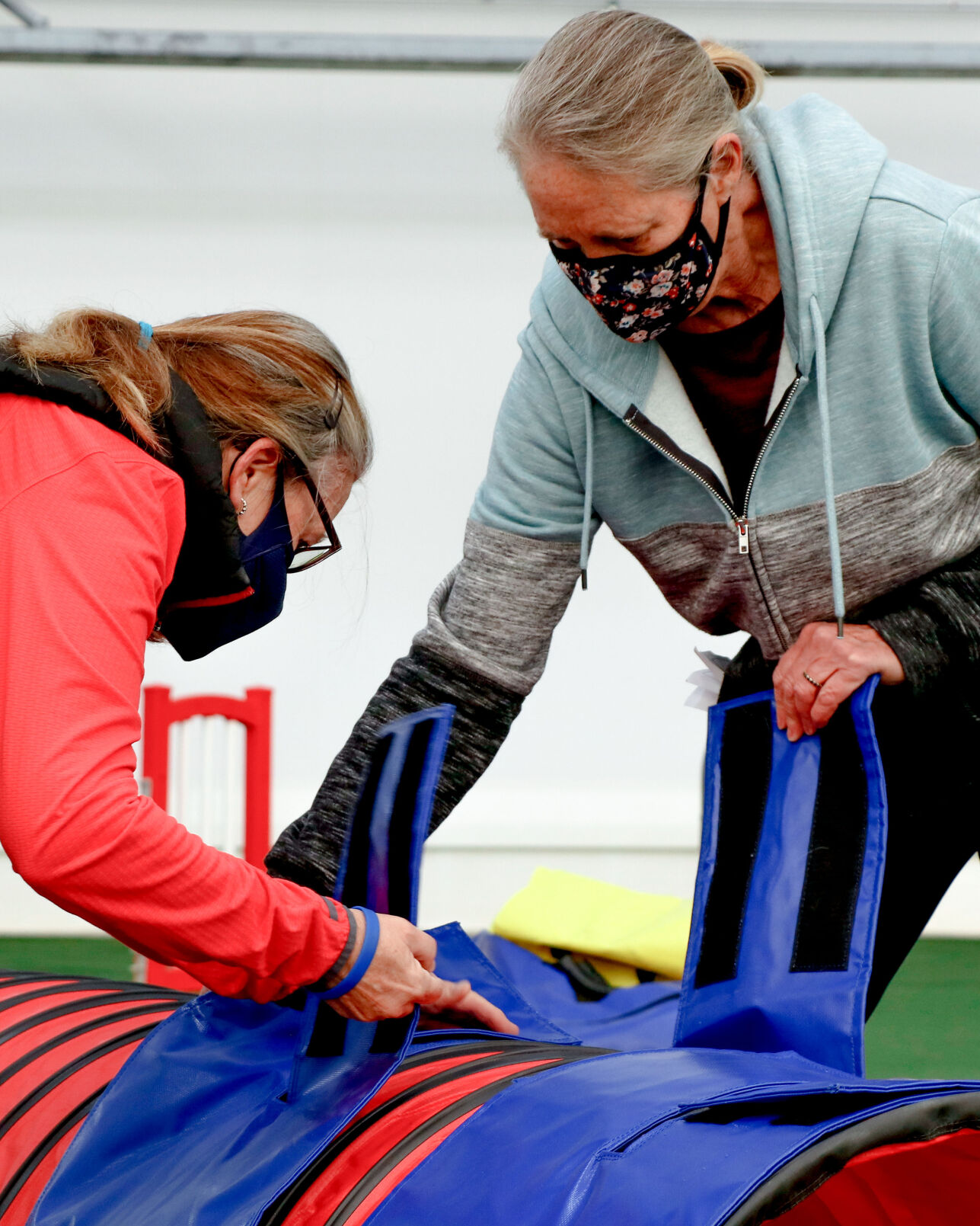 Laurie Donn, left, and Debbie Heifner strap sandbags on to the tunnel